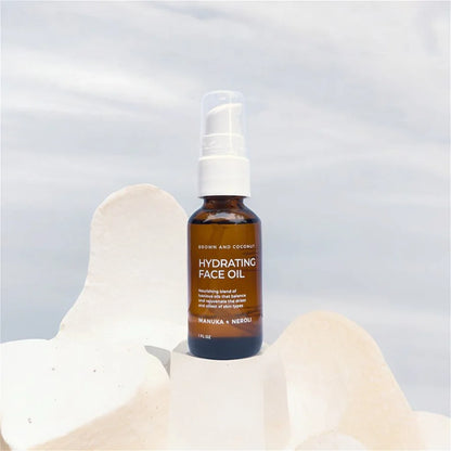 Brown and Coconut Hydrating Face Oil on a white rock