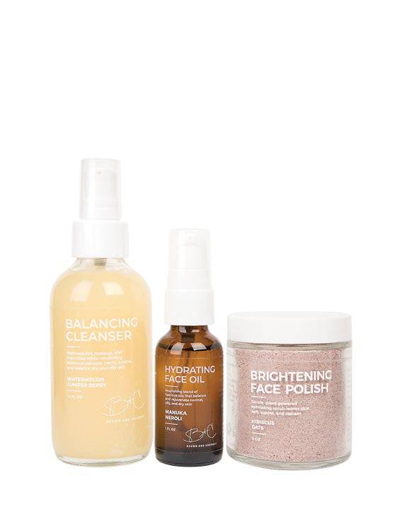 Brown and Coconut Rejuvenating Set with Balancing Cleanser, Hydrating Face Oil, and Brightening Face Polish on white background