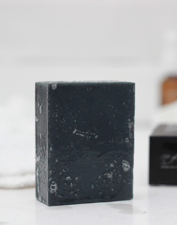 Brown and Coconut Deep Cleansing Charcoal Soap with soap box blurred in background