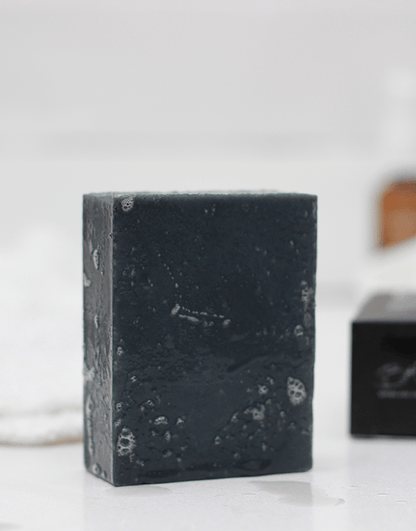 Brown and Coconut Deep Cleansing Charcoal Soap with soap box blurred in background